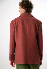 Bordowa kurtka z mieszanki wełny o dopasowanym kroju, z klapami i czarnymi guzikami na rękawach. Gładka tekstura i zorganizowany kształt.