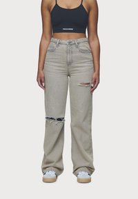 Heledhall hall denim laiad sääred teksad, millel on kulunud rebendid ja friseeritud servad. Omab kõrget vööd ja esipokke. Sobib musta lühikese topiga.