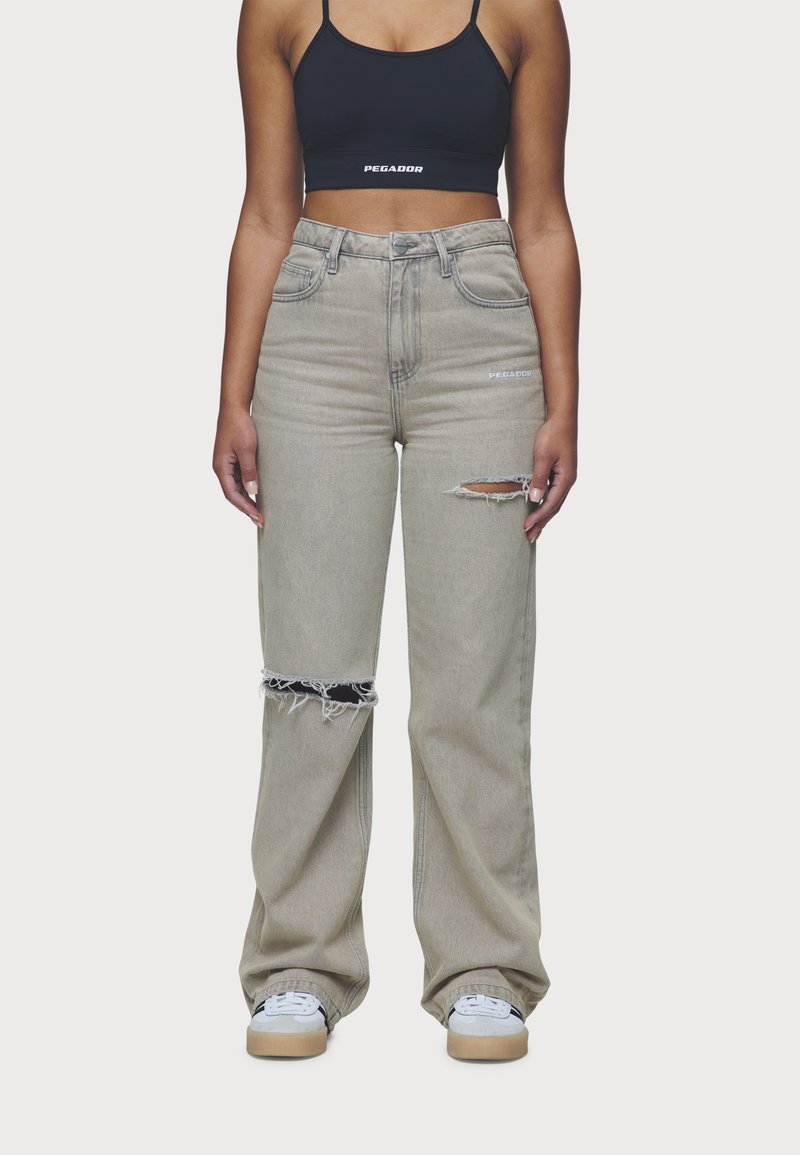 Heledhall hall denim laiad sääred teksad, millel on kulunud rebendid ja friseeritud servad. Omab kõrget vööd ja esipokke. Sobib musta lühikese topiga.