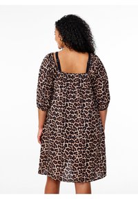 Leopard print dress with short puff sleeves, square back, and black straps. Made from lightweight fabric with a loose, flowing fit.
