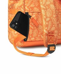 Orange backpack with leaf pattern, nylon material, and black phone partially visible in a side pocket. Features adjustable strap and buckle.