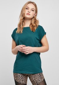 Teal kortärmad T-shirt i mjuk bomull med avslappnad passform. Matchas med leopardmönstrade leggings med en strukturerad yta.