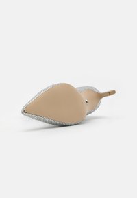 Zapato de tacón alto de malla plateada con punta afilada y suela en tono nude. Presenta una textura brillante con un tacón redondeado y un adorno decorativo.