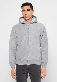 Grijze hoodie met ritssluiting, gevoerde capuchon met fleece, geribbelde manchetten en zoom, steekzakken aan de voorkant en een subtiel logo aan de zijkant.