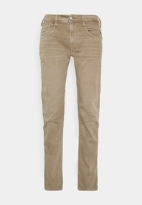 Jeans de corte slim en color beige, confeccionados con un suave tejido de algodón, que cuentan con cinco bolsillos, cierre de cremallera y detalles de costura sutil a lo largo de las costuras.