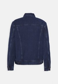 Veste en denim bleu foncé vue de dos, avec poignets et ceinture boutonnés, coutures apparentes sur les manches et les panneaux du corps.