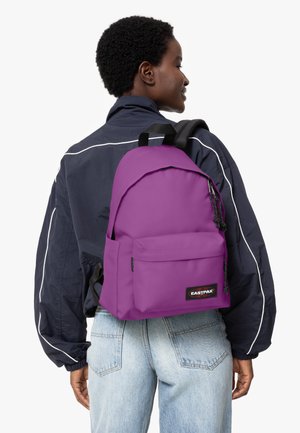 Lila Eastpak ryggsäck tillverkad av hållbart material med en framficka, justerbara remmar och en slät, matt yta.
