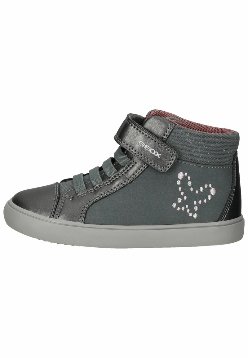 Zapatilla negra de caña alta con acentos grises, que presenta una correa de velcro y un diseño decorativo de corazón en detalles brillantes. Forro interior suave.