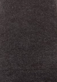 Dunkelgraue gerippte Socken aus einem weichen, strukturierten Material. Sie verfügen über ein nahtloses Zehendesign für zusätzlichen Komfort.