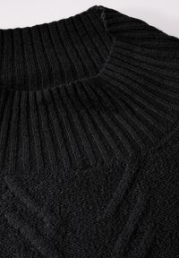 Maglione nero lavorato a maglia con un colletto alto a coste e un motivo a diamante testurizzato sul corpo. Tessuto morbido con un aspetto accogliente.