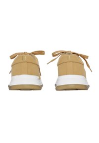 Zapatillas de ante beige con una suela media blanca, cordones texturizados y un sutil detalle del logotipo. Diseño redondeado y suela de goma.
