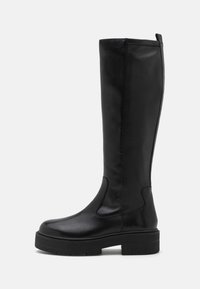 Stivali neri al ginocchio realizzati in pelle liscia con un design minimalista, suola spessa e pannello elastico laterale per una vestibilità più facile.