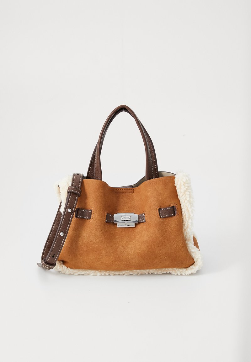 Sacs à main en suède marron avec des poignées et une bandoulière en cuir foncé, fermoir en argent, et garniture en shearling crème sur fond blanc.