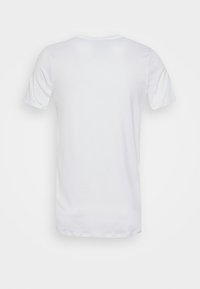 Camiseta blanca de manga corta, hecha de una tela ligera, con un diseño simple que presenta un cuello redondo y sin logotipos ni gráficos visibles.