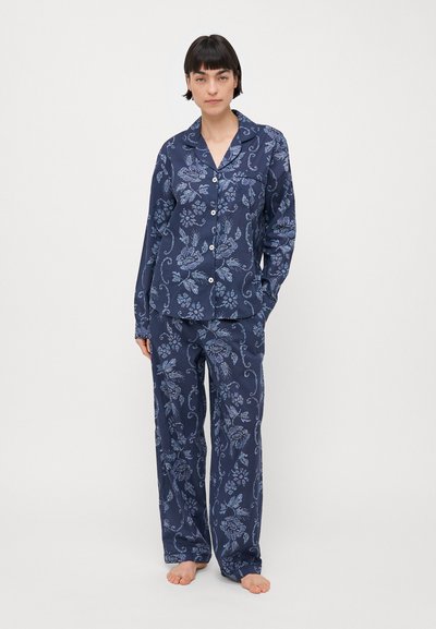 Navy blue pajama set featuring a floral pattern, long sleeves, button-up shirt, and loose-fitting pants in lightweight, soft fabric.