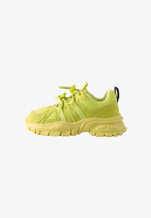 Lime green athletic sneaker with a mesh upper, rubber sole, and textured accents. Features adjustable laces and a black heel tab.