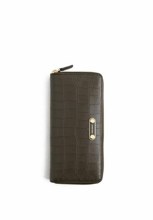 Portafoglio marrone scuro con zip a tutto giro, texture in coccodrillo e placca del marchio in metallo dorato sul davanti, fotografato su sfondo bianco.