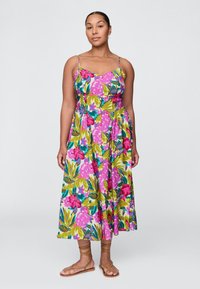 Vestido midi floral com padrões em rosa, verde e azul. Alças finas, corpete justo e saia fluida. Combina com sandálias castanhas de tiras.