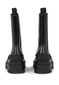 Zwarte enkelboots met een glanzend leren bovenwerk, elastische zijpanelen en een chunky rubberen zool met diepe profiel. Lussen aan de achterkant.