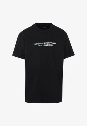 Czarna bawełniana koszulka z krótkimi rękawami, z białym napisem: "Doceniaj WSZYSTKO Oczekuj NIC" w różnych stylach czcionek.