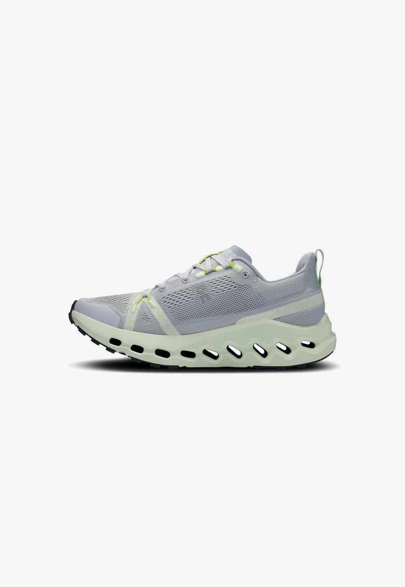 Chaussure de sport gris clair avec tige en mesh, accents vert clair et semelle épaisse distinctive avec découpes ovales noires.