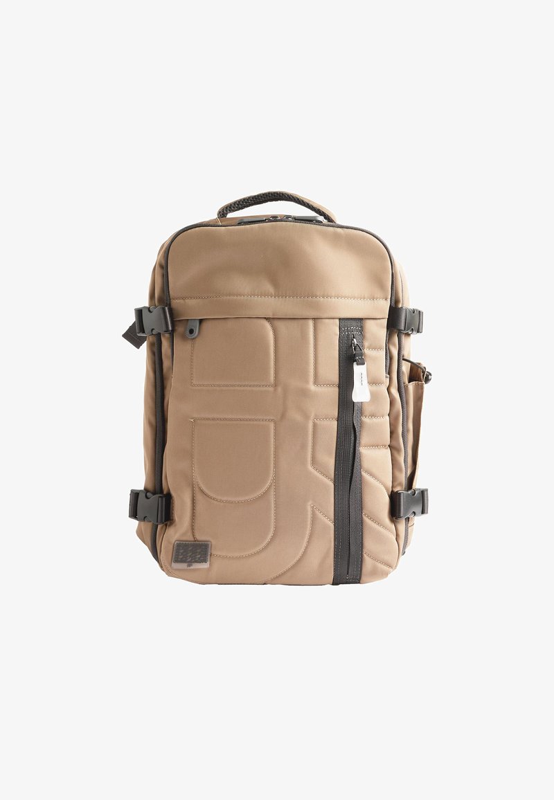 Beżowy plecak wykonany z fakturowanej tkaniny, z podkładem zewnętrznym, przednią kieszenią na zamek błyskawiczny, regulowanymi paskami oraz bocznymi klamrami do zamknięcia.