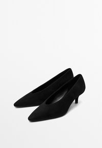 Chaussures à talons hauts en suède noir avec un bout pointu et un petit talon. Présentent un design découpé sur les côtés pour une silhouette élégante.