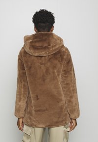 Brown faux fur coat featuring a hood, long sleeves, and a soft texture, designed with a relaxed fit. Back view shows no fastenings or details.