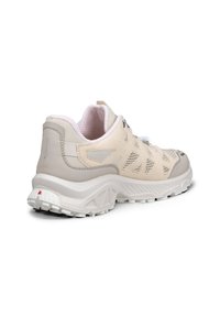 Sneakers sportives beige et blanches vues de dos, avec des panneaux en mesh, une semelle épaisse et un col de cheville rembourré.