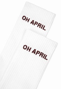 Hvide ribbede sokker med "OH APRIL" broderet i bordeaux øverst. Har et struktureret strikdesign for komfort og pasform.