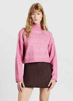 Maglione rosa corto lavorato a maglia con collo alto, caratterizzato da un motivo testurizzato. Abbinato a una gonna a trapezio corta di colore marrone scuro.