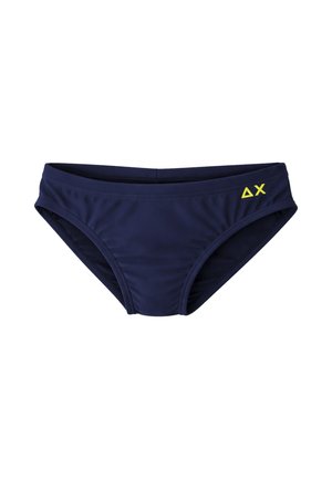 Costume da bagno slip a vita bassa blu navy con logo giallo ΔX sul lato destro, mostrato su sfondo bianco.