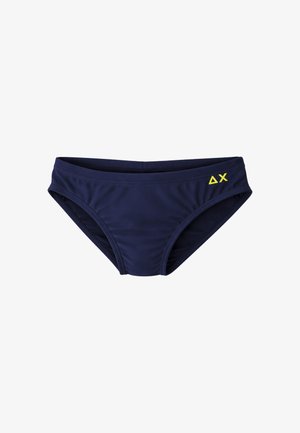 Costume da bagno slip a vita bassa blu navy con logo giallo ΔX sul lato destro, mostrato su sfondo bianco.
