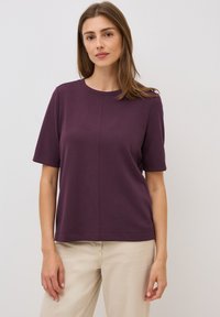 Paars top met korte mouwen van rekbaar materiaal, met een ronde halslijn en een rechte zoom. Eenvoudig ontwerp met een gladde textuur.