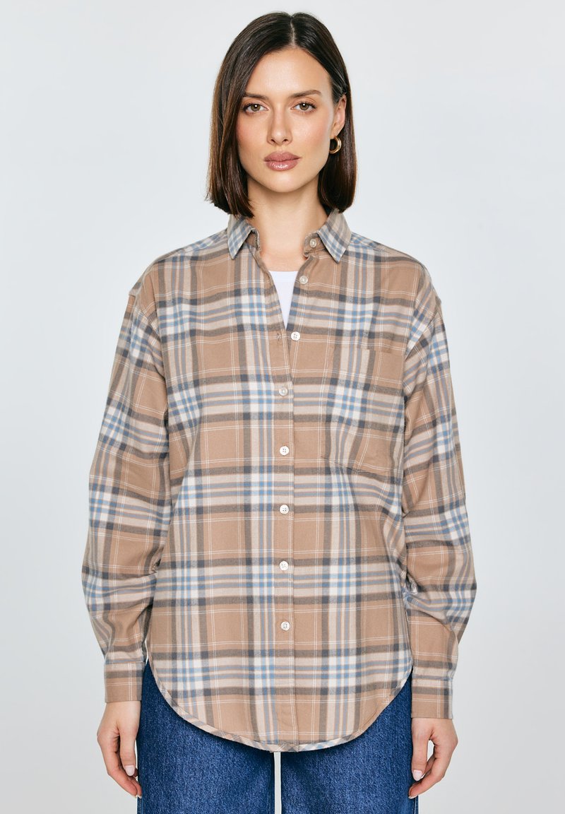 Cămașă în carouri maro cu accente albastre și albe, cu nasturi în față, mâneci lungi și tiv rotunjit. Confecționată dintr-o țesătură moale, cu croială lejeră.