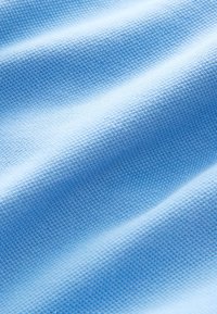 Világoskék szövött anyag texturált felülettel, finom, egységes mintával. Az anyag puhanak és simanak tűnik.