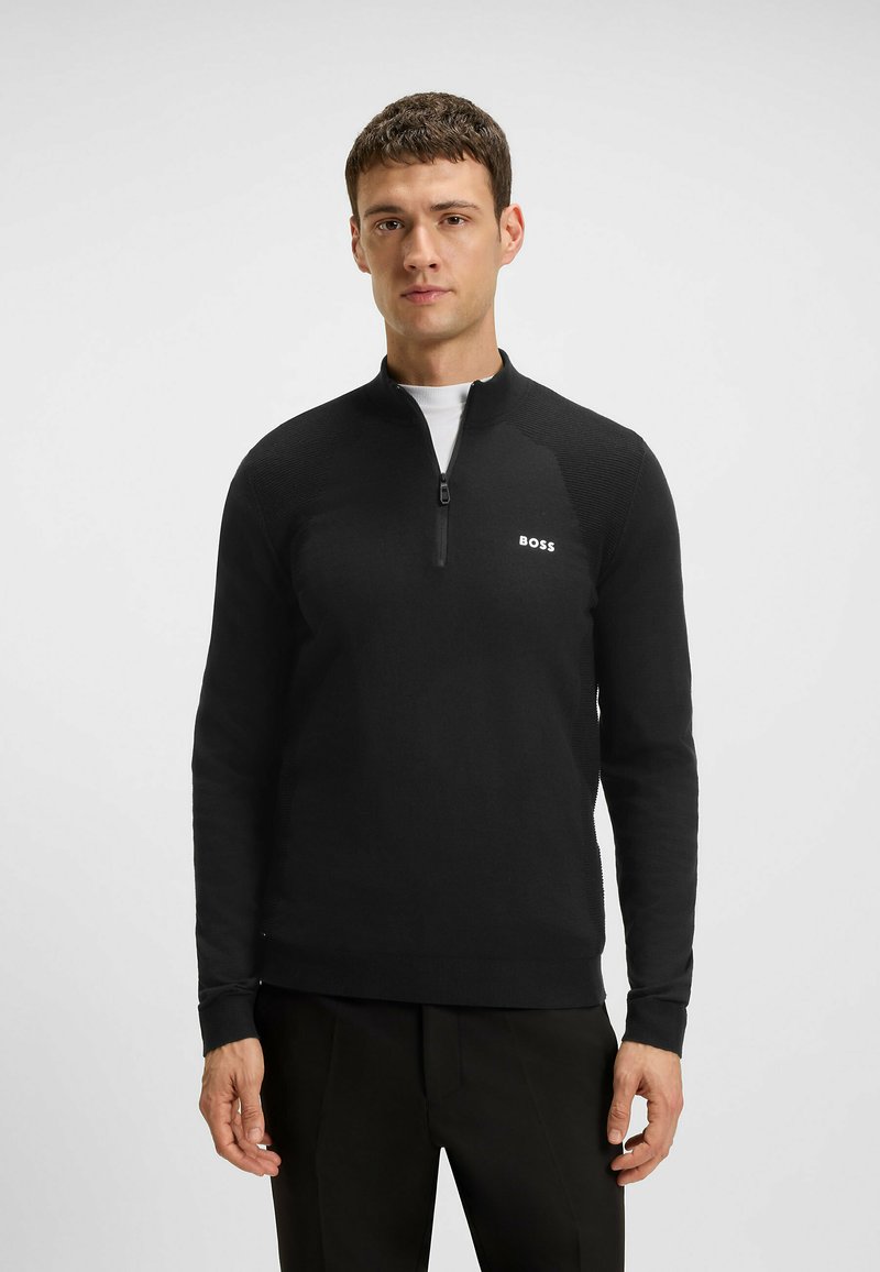 Schwarzer Zip-Hals-Pullover mit gerippter Textur an den Schultern und einem kleinen weißen "BOSS"-Logo auf der linken Brust. Lange Ärmel, taillierte Passform.