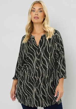 Schwarze Tunika-Bluse mit Knopfverschluss, ausgestattet mit weißen, wellenförmigen Linien- und Punktmustern, 3/4-Ärmeln und lässiger Passform.