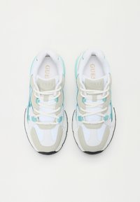 Fehér sneaker szürke és türkiszkék kiegészítőkkel, texturált felsőrésszel, párnázott nyakkal, fehér fűzőkkel és fekete gumitalppal.