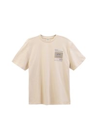 Lys beige bomulds t-shirt med korte ærmer, som har en frontlappe med tekst og design i mørkeblå og grå. Enkel rund hals.
