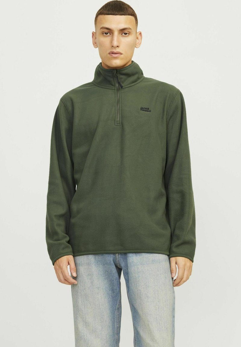Pullover in pile verde oliva con colletto alto, zip a un quarto e dettaglio logo nero sul petto. Maniche lunghe e texture morbida.