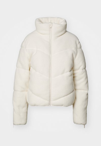 Weiße, strukturierte Pufferjacke mit hohem Kragen, Frontreißverschluss und Chevron-Muster. Verfügt über lange Ärmel und ein cropped Design.