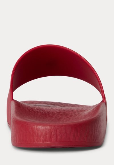 Czerwona klapka na płaskim spodzie z teksturowaną wkładką i szerokim pojedynczym paskiem, widziana z przodu na białym tle.