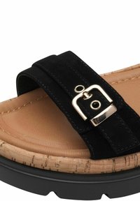 Black suede sandal with a wide strap, featuring a metallic buckle and a cork-like textured sole, complemented by a light brown footbed.
