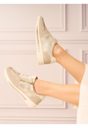 Baskets beiges en tissu métallique texturé, semelle blanche, devant lacé et détail de zip sur le côté. Accents en cuir lisse au talon et à la pointe.