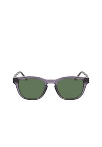 Occhiali da sole trasparenti viola con lenti verdi; forma angolare, montatura ampia e branding sottile sulla lente sinistra. Dettagli in metallo sulle cerniere.