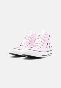 Ροζ ψηλά πάνινα παπούτσια με λευκά κορδόνια και σόλες, με μικρές διακοσμήσεις από μαύρα χάντρες στην εξωτερική πλευρά.