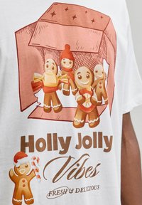 Patru figurine de turtă dulce zâmbitoare cu accesorii de sărbătoare într-o cutie deschisă deasupra textului "Vibe-uri festive delicioase și proaspete" pe un material alb.