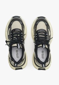 Czarno-beżowe sneakersy z siateczki z wyściełanymi podeszwami, teksturowanymi detalami i kontrastującymi białymi paskami. Posiadają czarne sznurówki i detale logo.