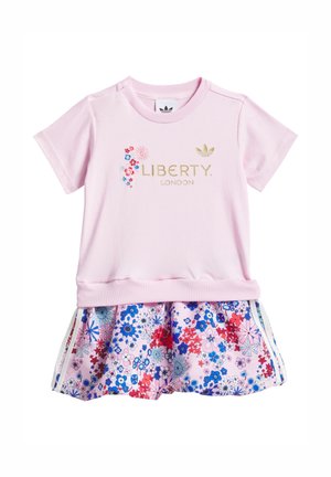 Top rosa a maniche corte con scritta dorata "Liberty London" e ricamo floreale, abbinato a una gonna rosa con motivo floreale che presenta fiori blu e rossi.